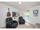 Inviting bonus room features carpet, guitars on the wall, two black leather chairs, and natural lighting at 4240 Camden Woods Ct, Raleigh, NC 27612