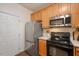 Kitchen with stainless steel appliances, black oven, wooden cabinets, and tile backsplash at 4240 Camden Woods Ct, Raleigh, NC 27612
