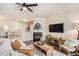 The well-lit living room includes a fireplace, a ceiling fan, hardwood floors, and a comfortable seating area at 4240 Camden Woods Ct, Raleigh, NC 27612