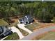 An aerial view of a stylish home with a long driveway, nestled among mature trees at 45 Hamilton Way, Youngsville, NC 27596