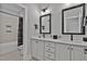 Bathroom featuring double vanity, white countertop, black framed mirrors, and view of tiled shower at 45 Hamilton Way, Youngsville, NC 27596