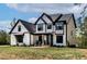 Beautifully built modern farmhouse with black framed windows and a lush green lawn at 45 Hamilton Way, Youngsville, NC 27596