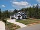 Stunning two-story home with a modern white exterior, black trim, and a spacious driveway at 45 Hamilton Way, Youngsville, NC 27596