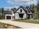 Beautiful modern farmhouse exterior, showcasing white siding and a long driveway at 45 Hamilton Way, Youngsville, NC 27596