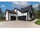 Exterior view of three-car garage with black doors and long driveway at 45 Hamilton Way, Youngsville, NC 27596