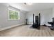 Home gym featuring a bike, weight lifting equipment, hardwood floors, and a large window at 45 Hamilton Way, Youngsville, NC 27596