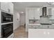 Bright kitchen featuring stainless appliances, light gray cabinetry, and tile backsplash at 45 Hamilton Way, Youngsville, NC 27596
