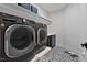 Contemporary laundry room featuring front load washer and dryer and patterned tile floor at 45 Hamilton Way, Youngsville, NC 27596
