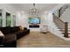 Comfortable living room with plush sofa, electric fireplace, flat screen TV, and staircase access at 45 Hamilton Way, Youngsville, NC 27596