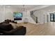 Bright living room with electric fireplace, mounted TV, comfortable seating, and staircase access at 45 Hamilton Way, Youngsville, NC 27596