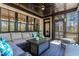 Inviting screened porch with wicker furniture, black window frames, and a dark stained wood deck at 45 Hamilton Way, Youngsville, NC 27596