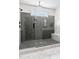 Modern bathroom shower with gray patterned tile, a glass door, and a built-in marble bench at 45 Hamilton Way, Youngsville, NC 27596