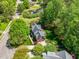 Aerial view of home showing mature trees, landscaping, yard, deck with umbrella, and proximity to pond at 4513 Touchstone Forest Rd, Raleigh, NC 27612
