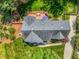 Expansive aerial view of a well-maintained property featuring lush landscaping and a charming backyard deck with a blue umbrella at 4513 Touchstone Forest Rd, Raleigh, NC 27612