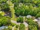 Beautiful aerial view showcasing the home's setting with mature trees, landscaping, and proximity to a pond at 4513 Touchstone Forest Rd, Raleigh, NC 27612