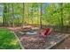 Wooded backyard with fire pit and seating at 4513 Touchstone Forest Rd, Raleigh, NC 27612