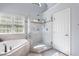 Bathroom featuring large shower with glass surround, soaking tub, and bright window at 4513 Touchstone Forest Rd, Raleigh, NC 27612