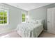 Neutral bedroom featuring two windows and light green walls at 4513 Touchstone Forest Rd, Raleigh, NC 27612