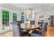 Dining room with hardwood floors, a round table, wainscotting, and access to outdoor deck through glass paneled double doors at 4513 Touchstone Forest Rd, Raleigh, NC 27612