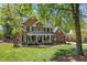 Two-story brick home with green lawn, mature trees, and a charming front porch at 4513 Touchstone Forest Rd, Raleigh, NC 27612