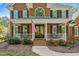 Beautiful brick home with a covered front porch, adorned with the American flag, creating a patriotic welcome at 4513 Touchstone Forest Rd, Raleigh, NC 27612