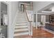 Elegant foyer featuring a staircase with white railing and hardwood floors, leading to an open layout at 4513 Touchstone Forest Rd, Raleigh, NC 27612