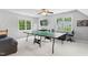 Spacious game room featuring a ping pong table, mounted television, and large windows at 4513 Touchstone Forest Rd, Raleigh, NC 27612