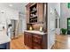 Spacious kitchen featuring custom wooden cabinets, a built-in bar, stainless steel refrigerator, and beautiful hardwood floors at 4513 Touchstone Forest Rd, Raleigh, NC 27612