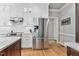 Modern kitchen with white cabinets, stainless steel refrigerator, white tile backsplash, hardwood floors, and granite countertops at 4513 Touchstone Forest Rd, Raleigh, NC 27612