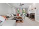 Cozy living room with plush carpeting, a fireplace, a ceiling fan, a large sectional, and natural light at 4513 Touchstone Forest Rd, Raleigh, NC 27612