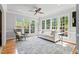 Comfortable living room with a ceiling fan, many windows, hardwood floors, white sofa, and neutral tones at 4513 Touchstone Forest Rd, Raleigh, NC 27612