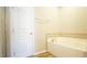 Bright bathroom with white bathtub, neutral tile surround, and door to shower at 4517 Pale Moss Dr, Raleigh, NC 27606