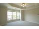 Sun-filled bedroom featuring plush carpet, ceiling fan, and multiple large windows at 4517 Pale Moss Dr, Raleigh, NC 27606