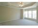 Expansive bedroom with tray ceilings, plush carpet, ceiling fan, and large windows at 4517 Pale Moss Dr, Raleigh, NC 27606