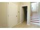 Neutral-toned entryway featuring tile flooring, staircase, and white doors leading to various rooms at 4517 Pale Moss Dr, Raleigh, NC 27606