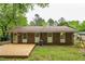 Backyard featuring a deck, brick home exterior, lawn, and mature trees at 508 Solar Dr, Raleigh, NC 27610