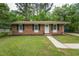 Quaint brick home featuring black shutters, a tidy lawn, and a concrete walkway to the front door at 508 Solar Dr, Raleigh, NC 27610