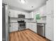 Updated kitchen with stainless steel appliances and white cabinetry, offering a sleek and efficient workspace at 508 Solar Dr, Raleigh, NC 27610