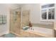 Bright bathroom with tile shower and soaking tub under window with plantation shutters at 511 Hillsborough St # 103, Chapel Hill, NC 27514