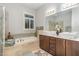 Elegant bathroom featuring a soaking tub, double vanity, and natural light from the window at 511 Hillsborough St # 103, Chapel Hill, NC 27514