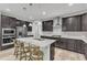 Modern kitchen with dark cabinets, an island with seating, granite countertops and stainless appliances at 512 Flip Trl, Cary, NC 27513