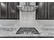 Modern cooktop with stainless range hood and subway tile backsplash, above granite countertops at 512 Flip Trl, Cary, NC 27513