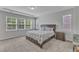 Serene main bedroom featuring a large bed, tray ceiling, and plenty of natural light at 512 Flip Trl, Cary, NC 27513
