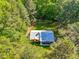 Aerial shot of home with a white roof surrounded by lush green trees at 5204 William And Mary, Raleigh, NC 27616