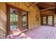 Spacious covered back porch with wood floors and wood walls featuring glass doors at 5204 William And Mary, Raleigh, NC 27616