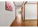 Bright hallway with hardwood floors, white walls, and wood trim leading to a dining area at 5204 William And Mary, Raleigh, NC 27616