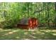 View of the exterior of a red shed in a wooded area at 5204 William And Mary, Raleigh, NC 27616