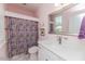 Cheerful bathroom with white vanity, white toilet, decorative wall art, and colorful shower curtain at 524 Auguston Ct, Sanford, NC 27330