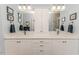 Light and bright bathroom with double sinks, white cabinets and large mirrors with unique sconces at 524 Auguston Ct, Sanford, NC 27330