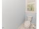 Powder room with white toilet and marble floor tiles, next to window with white blinds at 524 Auguston Ct, Sanford, NC 27330
